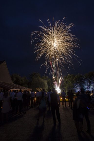 Feuerwerk erleuchtet den Nachthimmel über einer Menschenmenge.